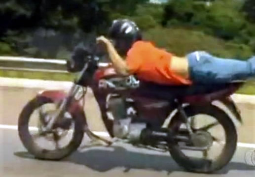 Jovem pilotava deitado na moto em Lavras e outro empinando o veículo