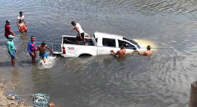 Sem motorista, caminhonete desce ladeira e cai dentro de rio