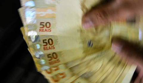 notas de 50 reais sendo seguradas | 13º salario