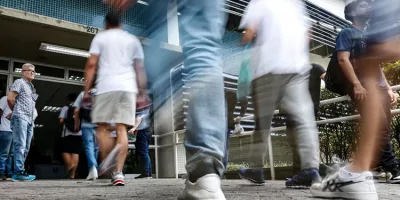 pessoas caminhando para prestar concurso publico.