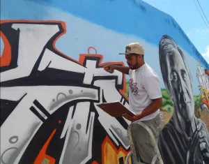 Parede sendo pintada com a técnica de grafite, em Juazeiro do Norte.