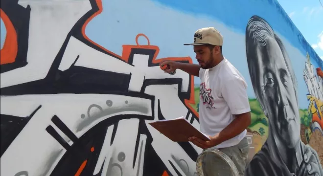 Parede sendo pintada com a técnica de grafite, em Juazeiro do Norte.