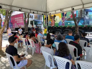 Pessoas sentadas em cadeira no Mutirão PopRuaJud, voltado ao atendimento de pessoas em situação de rua.