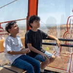 Duas crianças sentadas em passeio no Teleférico do Horto, em Juazeiro do Norte.