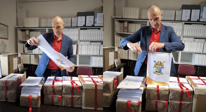 Abertura das atas do ínquerido de beatificação do Padre Cícero. Mostra um homem com os papeís na mesa abrindo com uma tesoura os envelopes