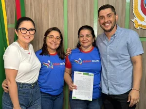 Assinatura do termo do projeto “Educação e Cidadania 2025”, de Várzea Alegre. A imagem mostra quatro pessoas, sendo três mulheres, da querda para a direita e um homem, que é o prefeito da cidade. Uma delas está segurando o papel.