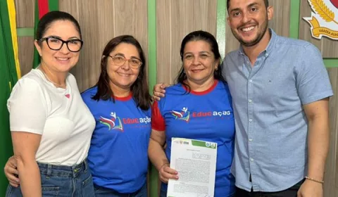 Assinatura do termo do projeto “Educação e Cidadania 2025”, de Várzea Alegre. A imagem mostra quatro pessoas, sendo três mulheres, da querda para a direita e um homem, que é o prefeito da cidade. Uma delas está segurando o papel.