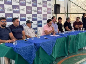 vereadores de juazeiro do norte durante edição do projeto "Câmara com o Povo". eles estão sentados em uma mesa coberta com tecidos azuis e verdes,