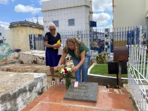 Duas mulheres colocando flores em cima de um jazigo durante o Dia de Finados em Juazeiro do Norte.