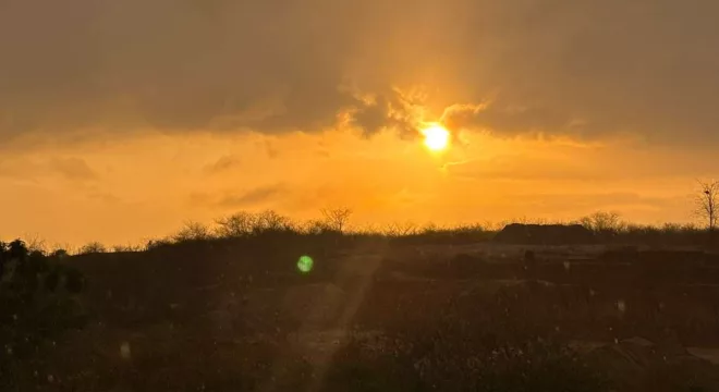 Imagem mostra o entardecer no Ceará. O céu está alaranjado e com temperatura que varia de 35ºC a 39º C.