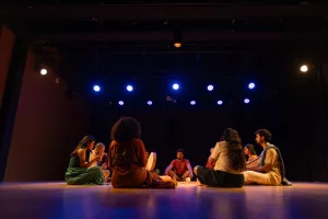 Pessoas sentadas em um circulo durante a finalização da residencia de laboratório percuciêncoa som na cena, do centro cultural do cariri.