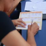 Pessoa preenchendo cartão de vacina.