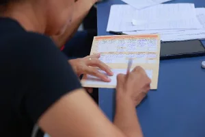 Pessoa preenchendo cartão de vacina.