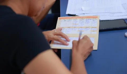 Pessoa preenchendo cartão de vacina.