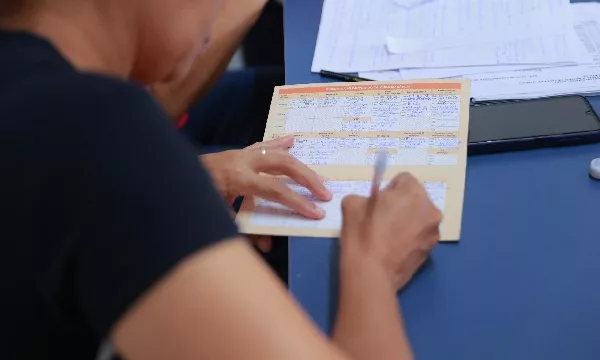 Pessoa preenchendo cartão de vacina.