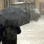 Pessoa andando na rua. Chuva na cidade.