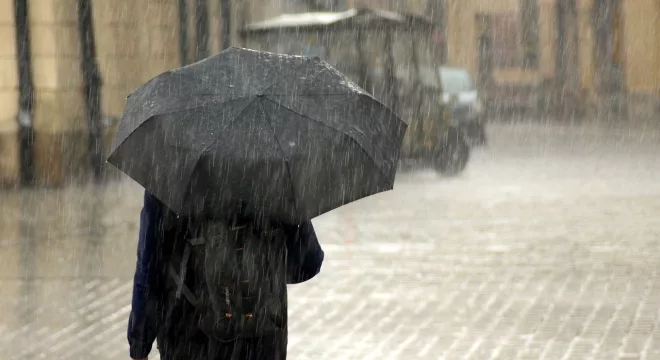 Pessoa andando na rua. Chuva na cidade.