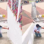 Mãe subindo os degraus de acesso a estatua do Padre Cícero, em Juazeiro do Norte, de joelhos e com a filha no colo para pagar promessa.