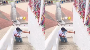 Mãe subindo os degraus de acesso a estatua do Padre Cícero, em Juazeiro do Norte, de joelhos e com a filha no colo para pagar promessa.