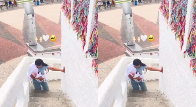 Mãe subindo os degraus de acesso a estatua do Padre Cícero, em Juazeiro do Norte, de joelhos e com a filha no colo para pagar promessa.