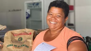Mulher recebendo as sementes do Programa Hora de Plantar.