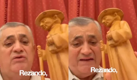 José Guimarães segurando uma imagem do Padre Cícero.