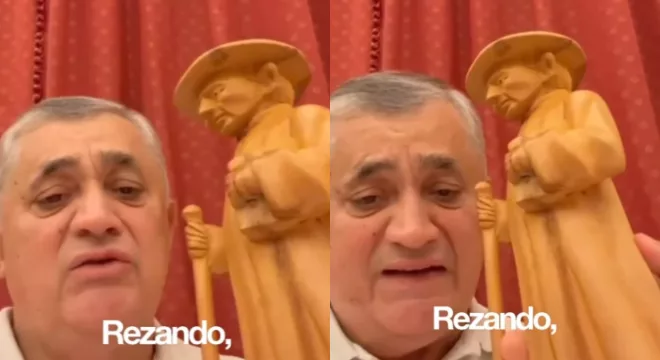 José Guimarães segurando uma imagem do Padre Cícero.