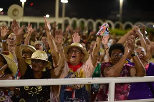 Mulher em multidão orando durante a Romaria de Candeias.