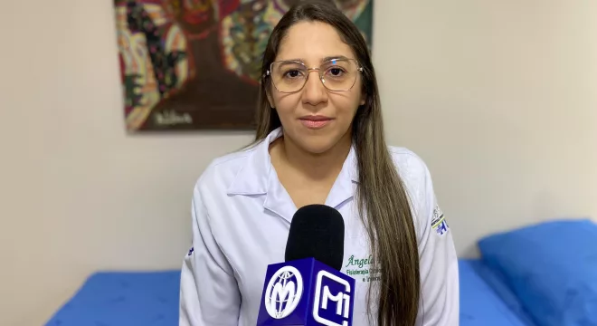 Ângela Rolim, fisioterapeuta intensivista do Hospital Santo Antônio, em Barbalha. A imagem mostra ela em frente a canopla no M1, durante entrevista para falar sobre Alzheimer.