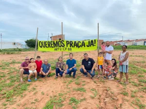 Moradores do bairro Monsenhor Murilo em Juazeiro do Norte, em frente a uma faixa com a frase: “Queremos praça já! Art° 6 da CF 88”.