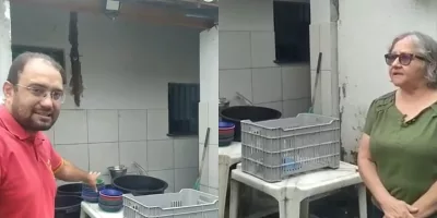 Dois servidores mostrando a cantina da escola municipal em Juazeiro do Norte com precariedade.