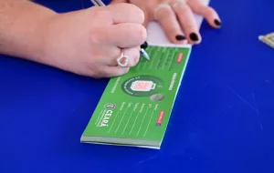 pessoa recebendo o vale gás. a imagem está focada nas mãos