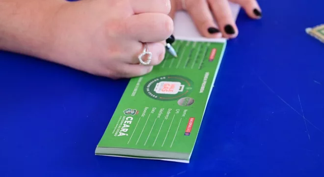 pessoa recebendo o vale gás. a imagem está focada nas mãos