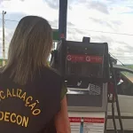 Fiscalização do decon em estabelecimentos da região do Cariri. A foto mostra uma mulher de costas fiscalizando um posto de gasolina.