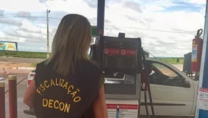 Fiscalização do decon em estabelecimentos da região do Cariri. A foto mostra uma mulher de costas fiscalizando um posto de gasolina.